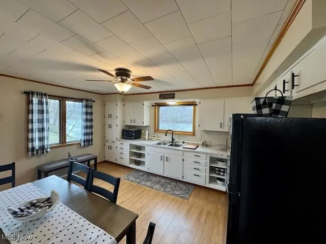 Kitchen featuring plenty of natural light, light countertops, freestanding refrigerator, and a sink