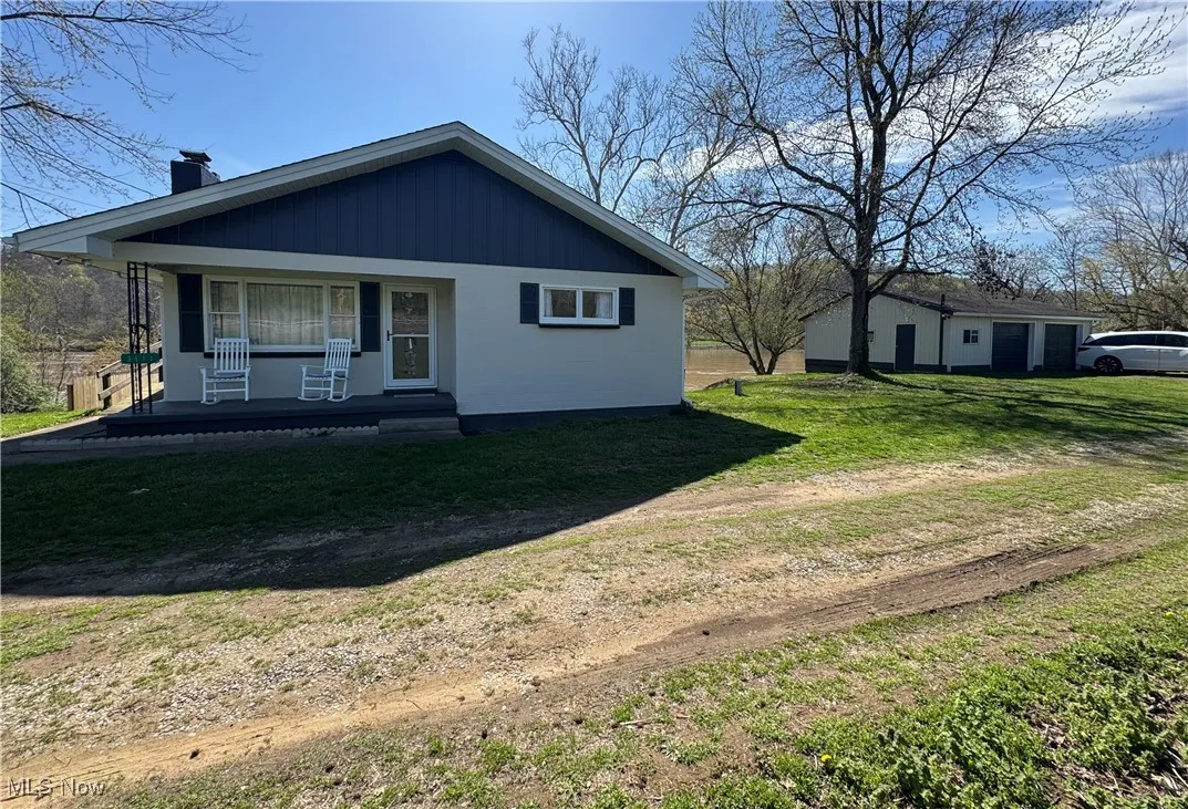 View of front of home featuring a front yard, a porch, and a chimney