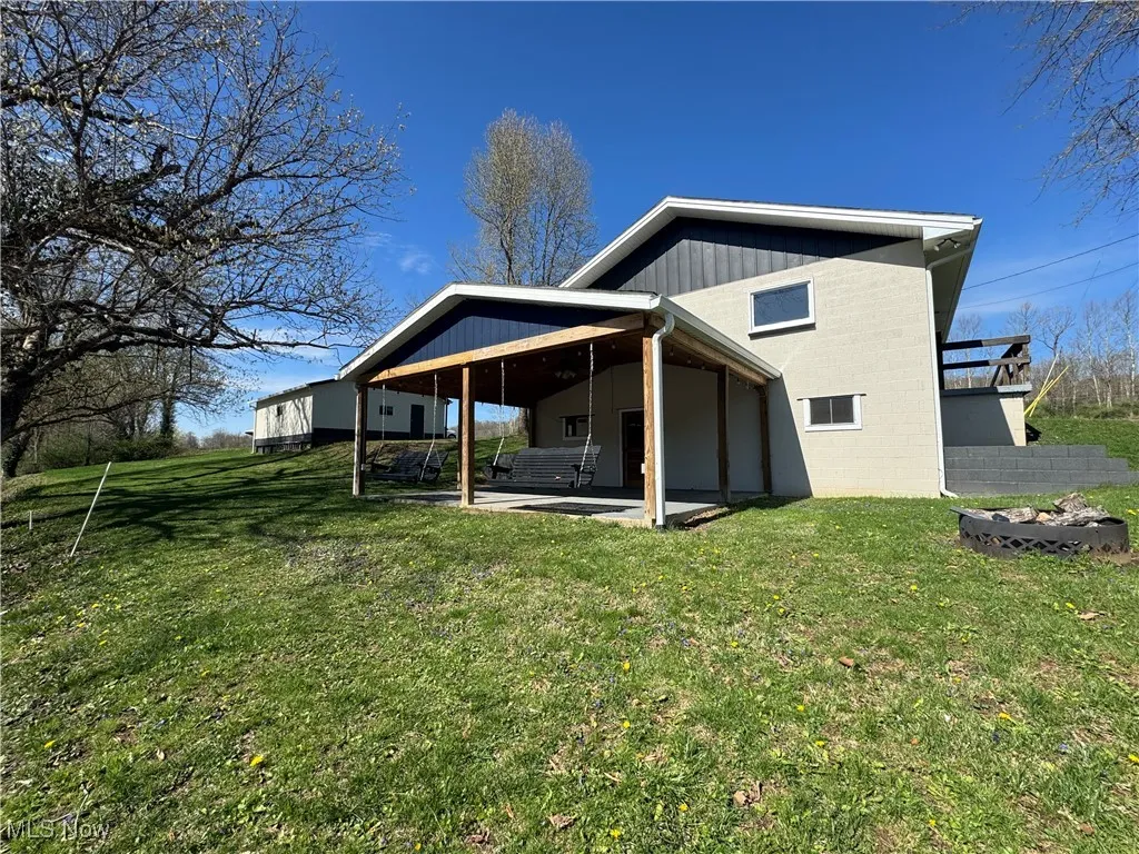 Back of property featuring a patio area and a lawn