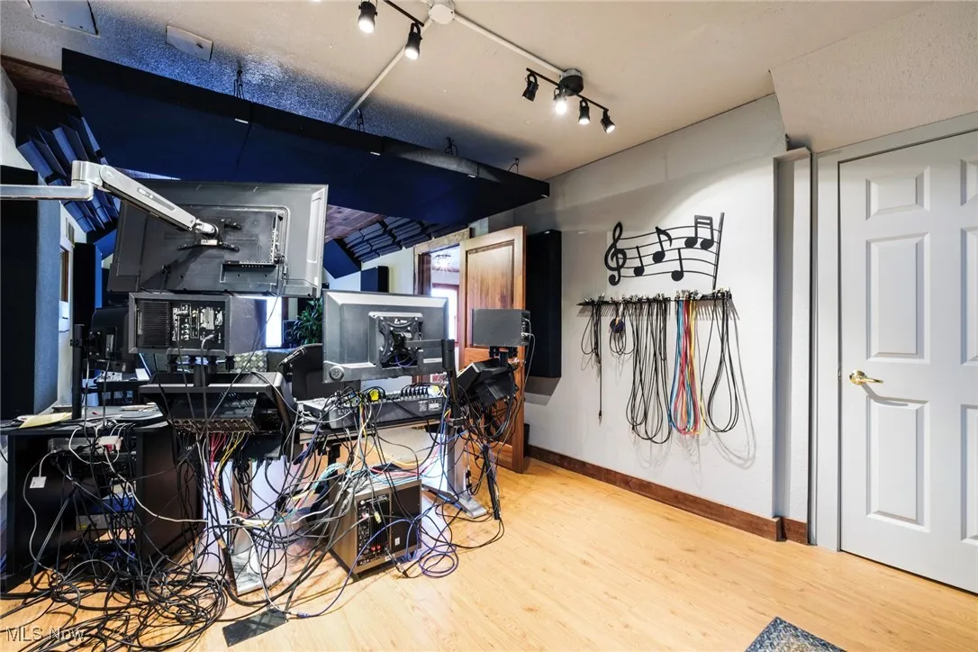 Miscellaneous room with rail lighting, baseboards, and wood finished floors