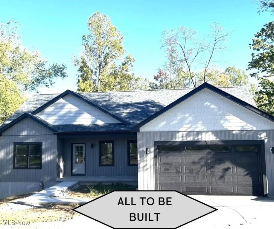 Modern farmhouse featuring an attached garage, driveway, and a shingled roof