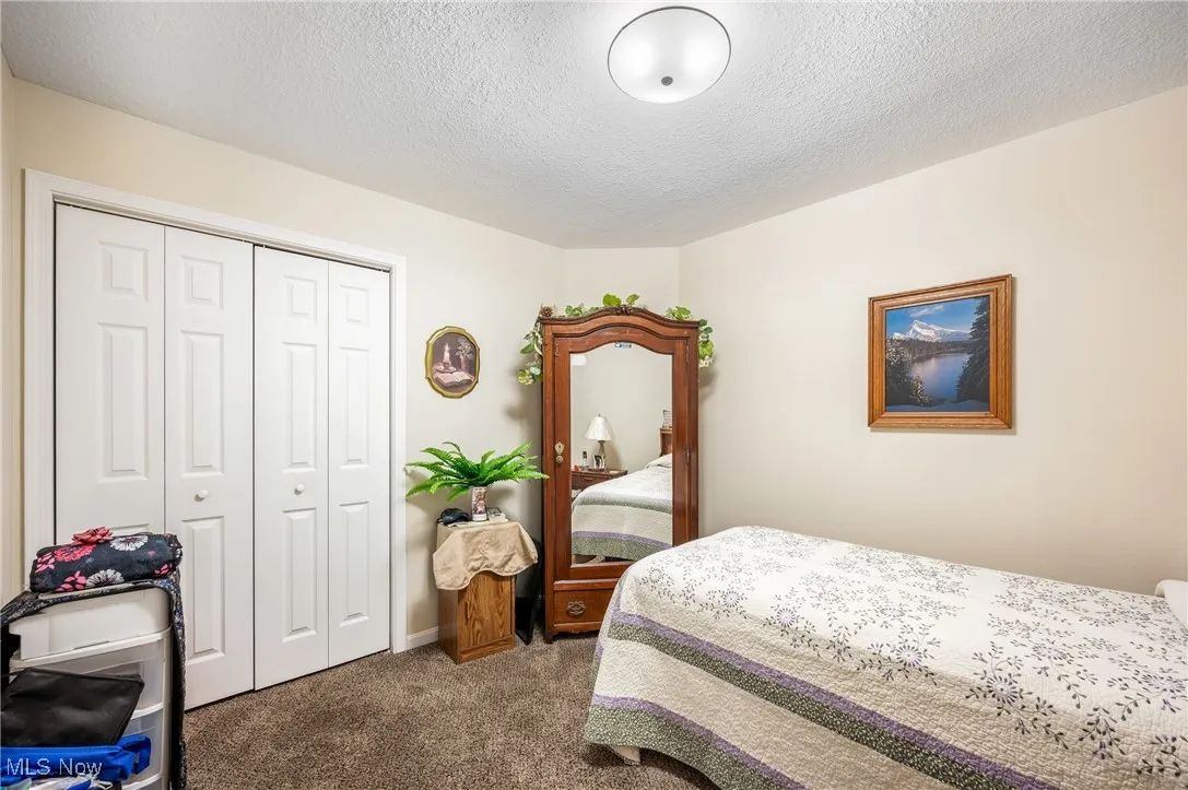 Bedroom featuring a closet, carpet flooring, and a textured ceiling