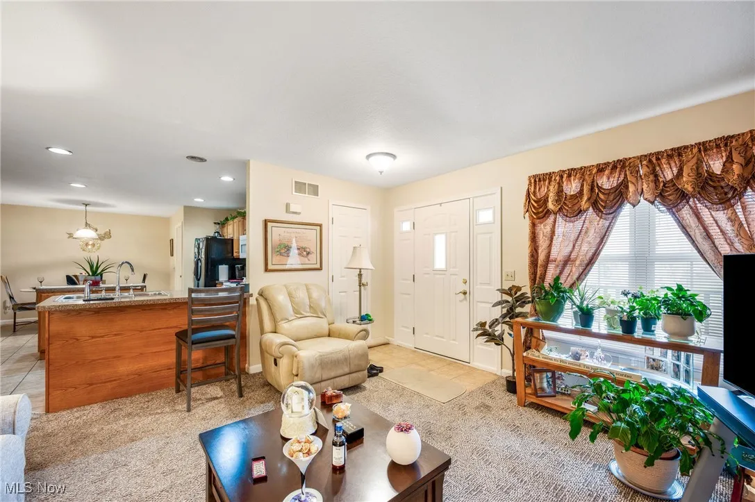 Living area featuring baseboards, visible vents, recessed lighting, and light tile patterned floors
