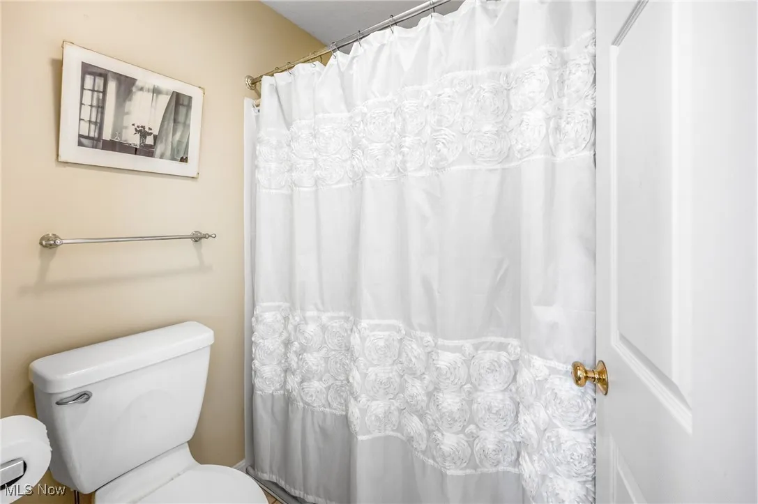 Bathroom with toilet and a shower with curtain