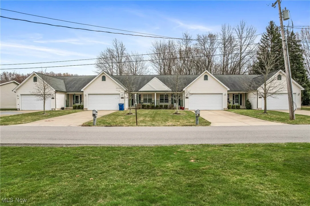 Ranch-style house featuring a front lawn, an attached garage, and concrete driveway