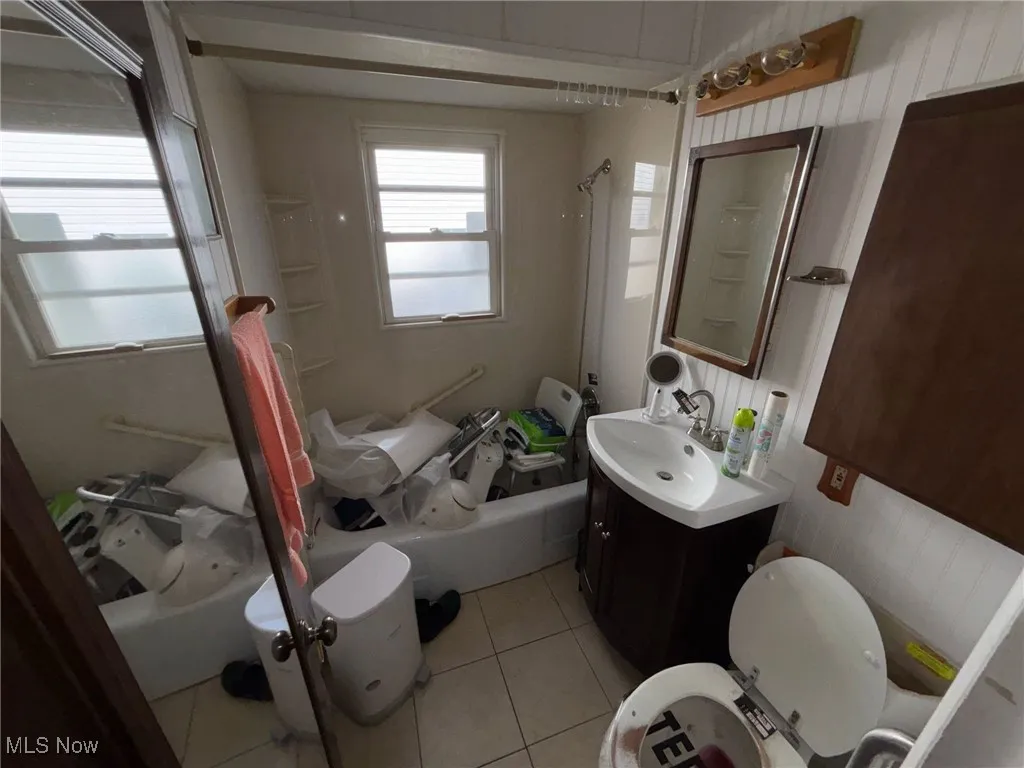 Full bathroom featuring bathing tub / shower combination, toilet, tile patterned flooring, and vanity