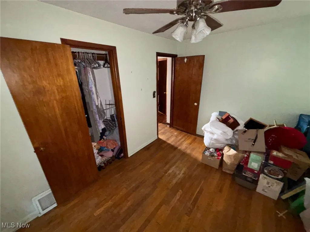 Bedroom with visible vents, wood finished floors, and ceiling fan