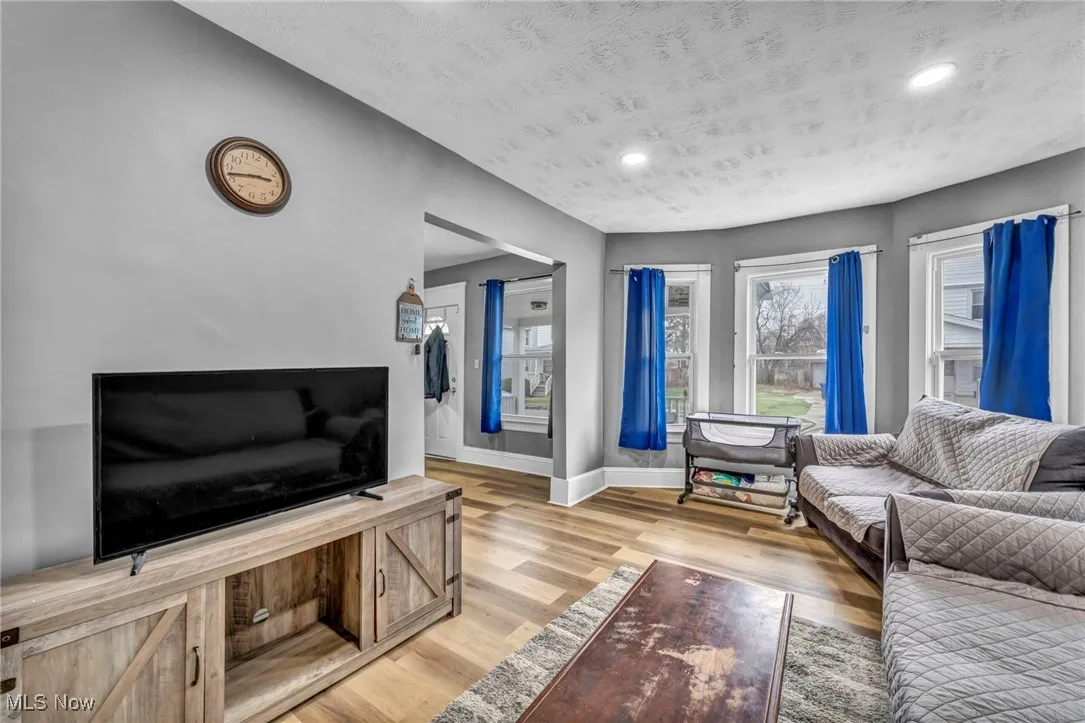 Living area featuring light wood finished floors, baseboards, and recessed lighting