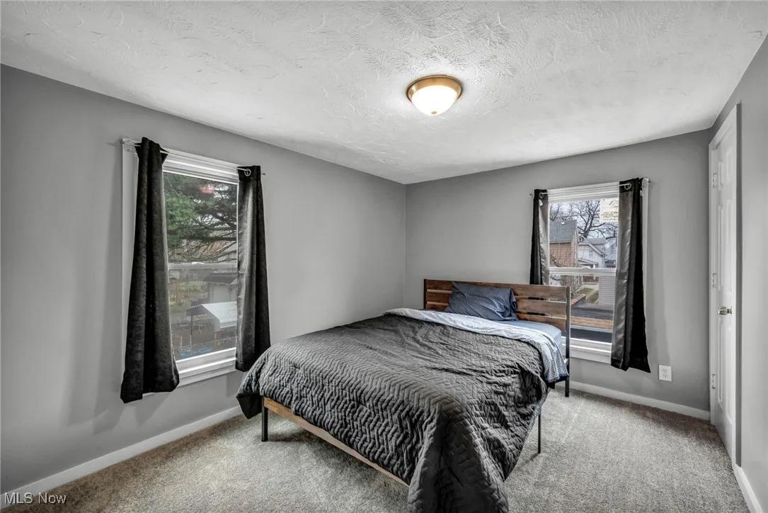 Bedroom featuring baseboards, carpet floors, and a textured ceiling