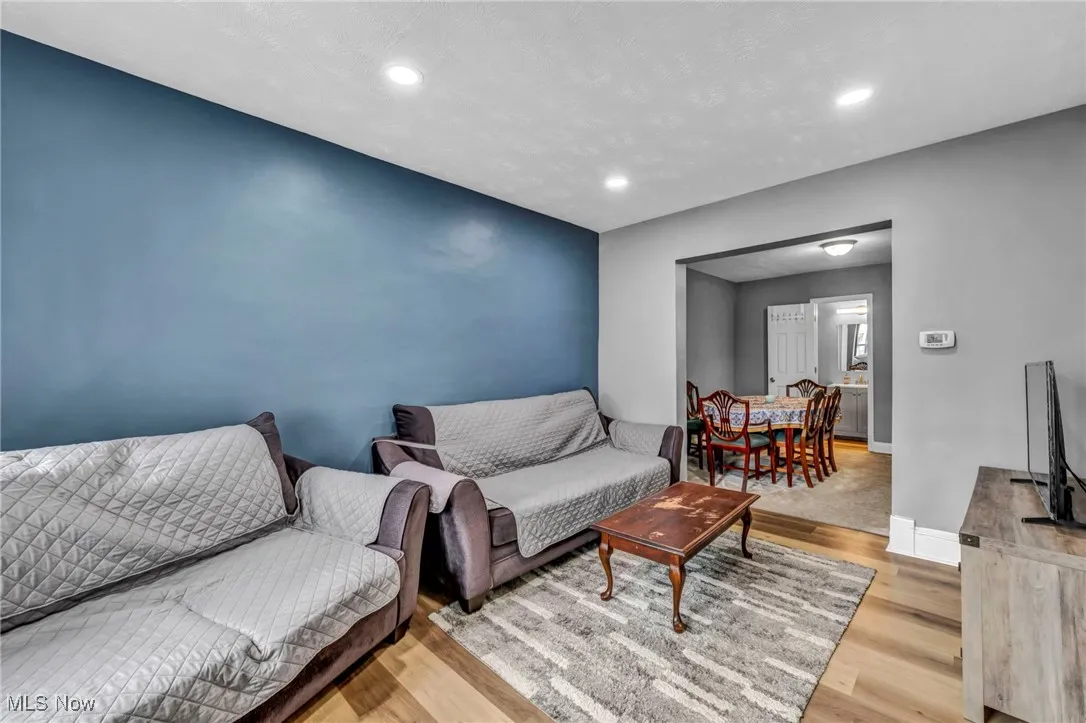 Living room with baseboards, wood finished floors, and recessed lighting