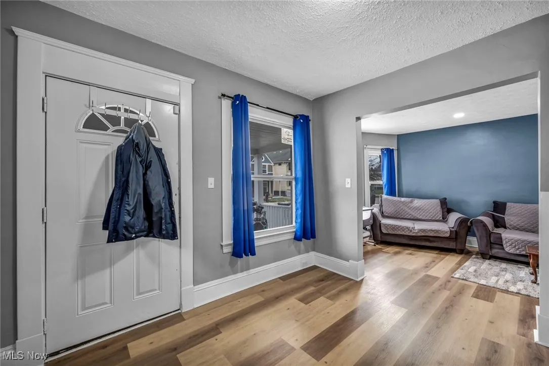 Entryway featuring a textured ceiling, baseboards, and wood finished floors