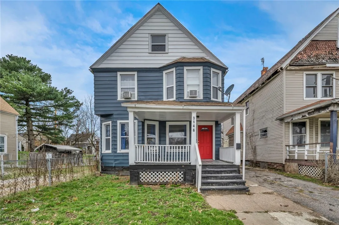 View of front of property featuring covered porch and fence