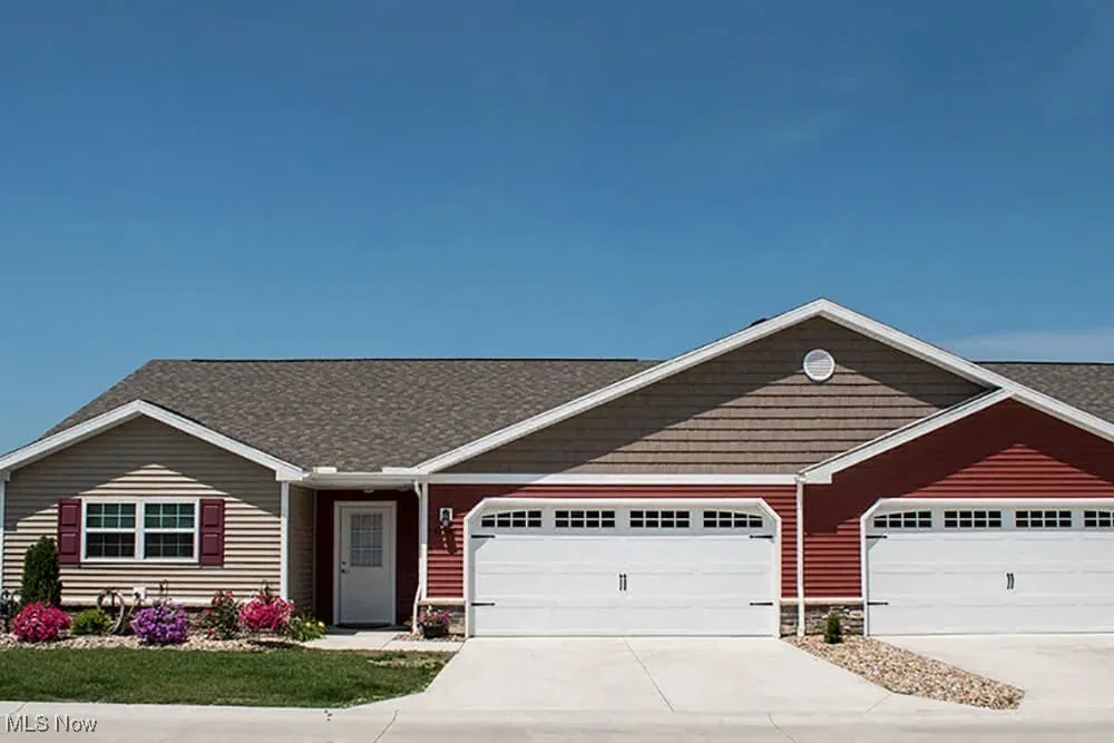 Ranch-style home featuring stone siding, concrete driveway, an attached garage, and a shingled roof