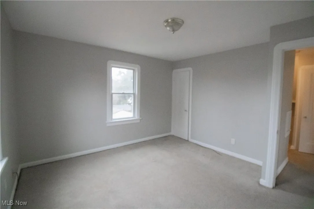 Unfurnished bedroom featuring light colored carpet and baseboards