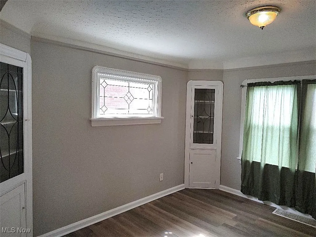 Dining room with white baseboards, vinyl wood-style floors, and built-in cabinets