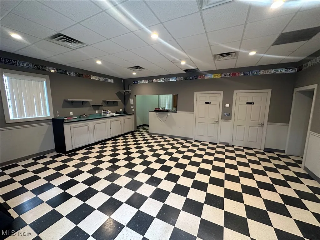 Kitchen featuring white cabinetry and a paneled ceiling