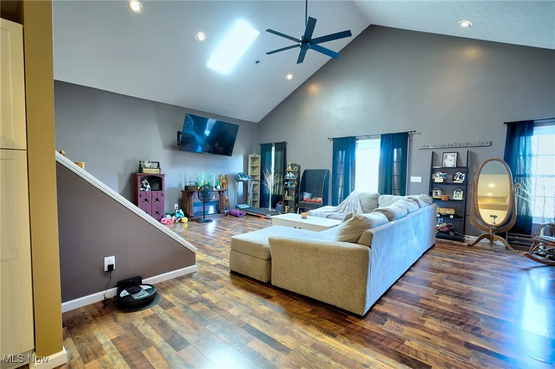 Living area with plenty of natural light, wood finished floors, and a ceiling fan