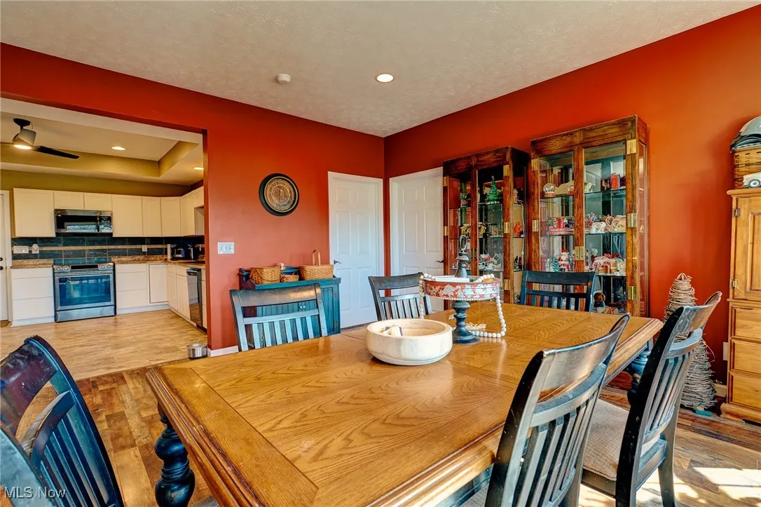 Dining area featuring a textured ceiling, light wood-type flooring, recessed lighting, and a ceiling fan