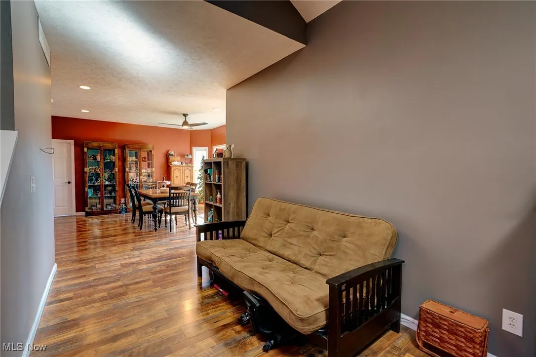 Sitting room with a ceiling fan, wood finished floors, a textured ceiling, baseboards, and recessed lighting
