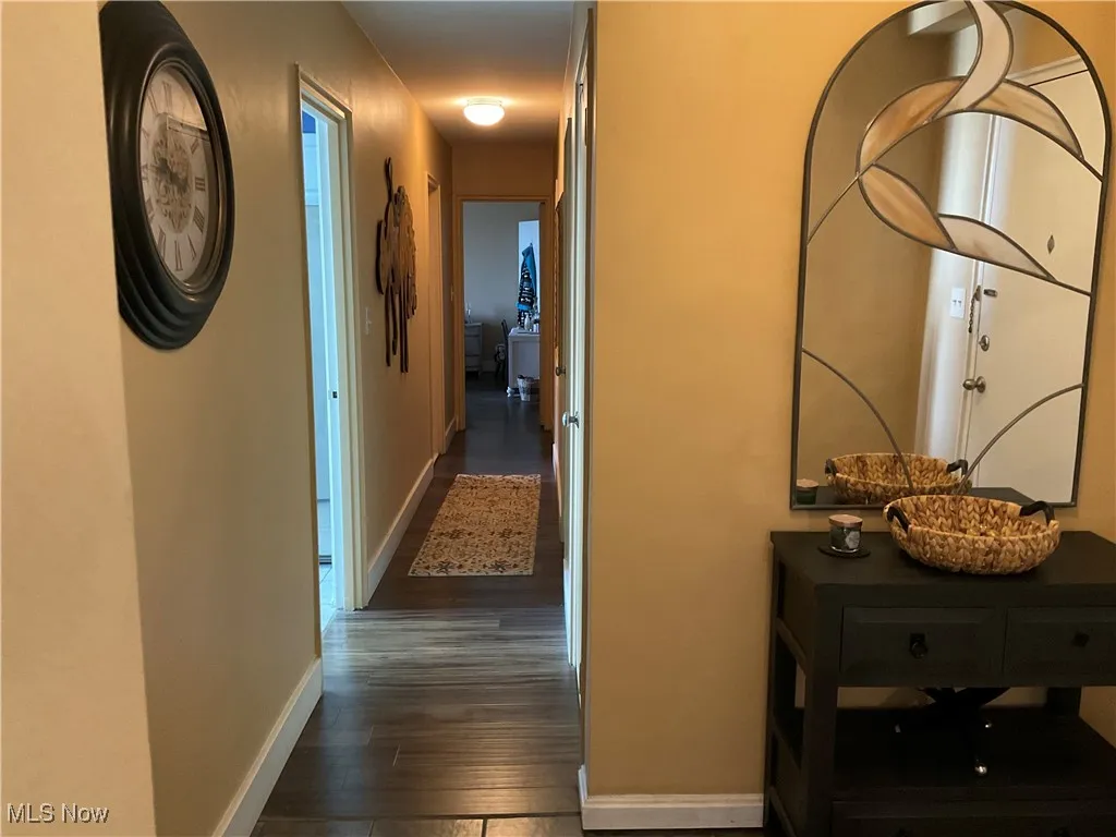 Hallway with dark wood finished floors and baseboards