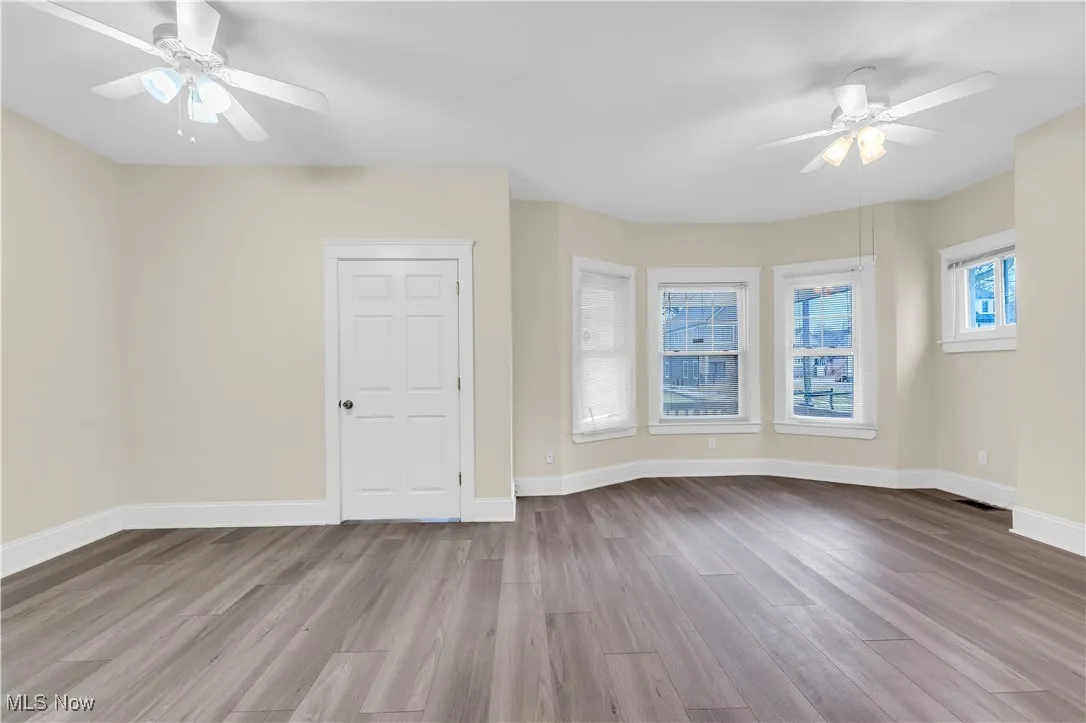 Spare room featuring baseboards, visible vents, wood finished floors, and ceiling fan