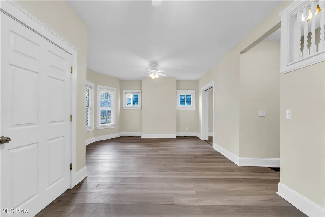 Entrance foyer with baseboards, dark wood-style floors, and a ceiling fan
