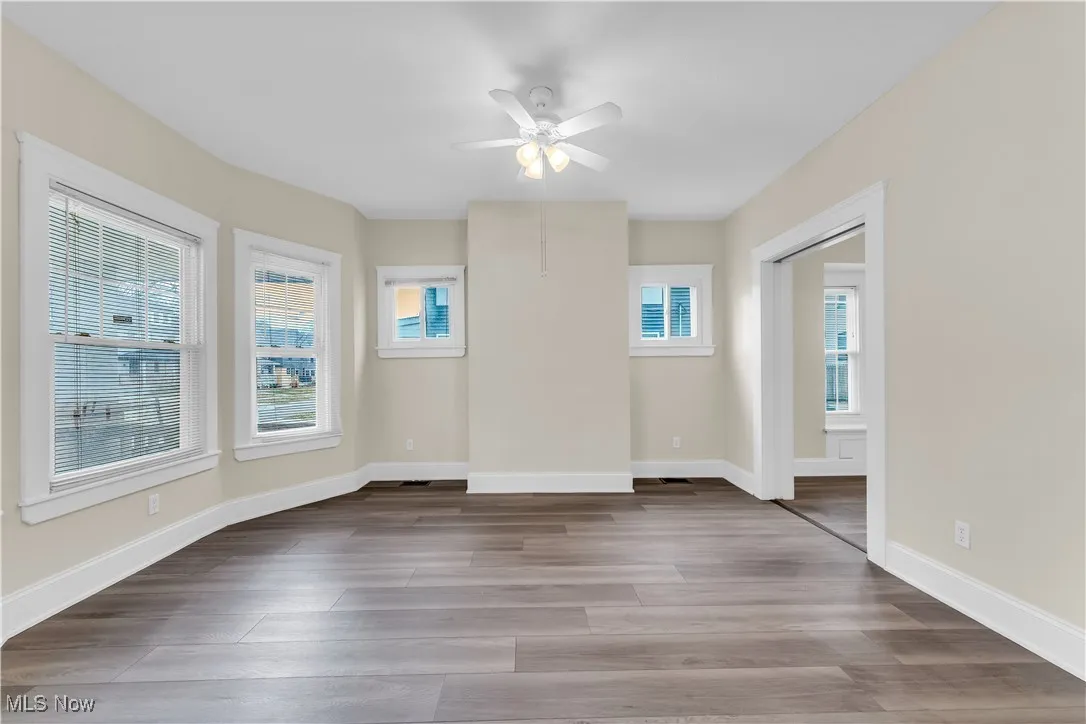 Spare room with wood finished floors, baseboards, and ceiling fan