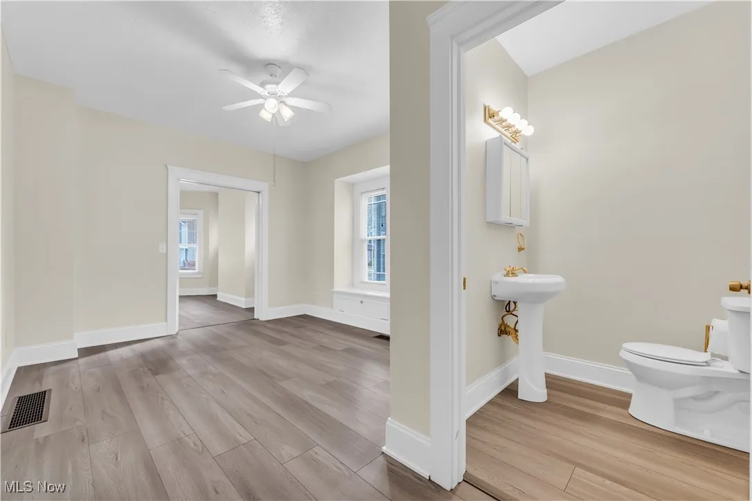 Bathroom featuring a healthy amount of sunlight, toilet, visible vents, a ceiling fan, and wood finished floors