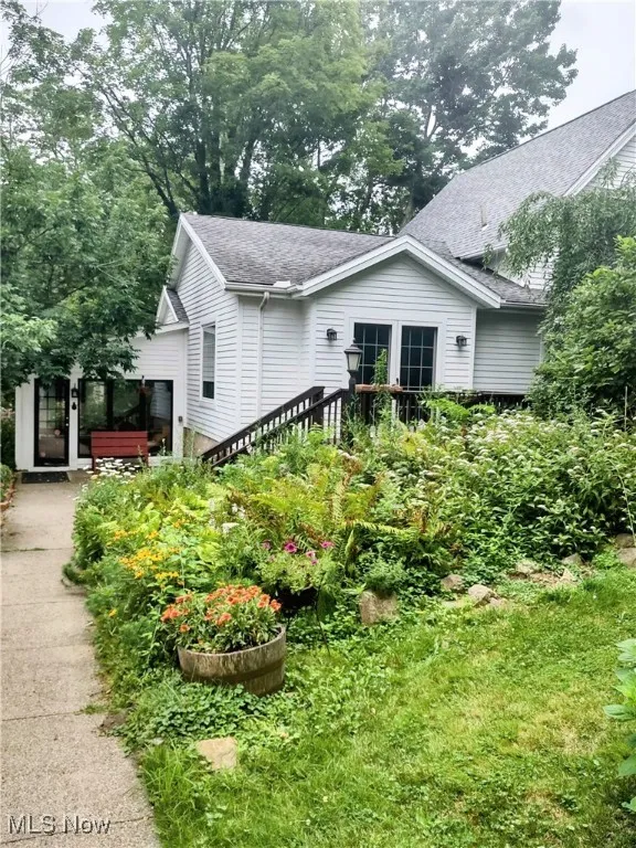 View of home's exterior with driveway and roof with shingles