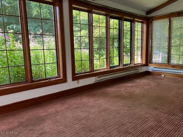 Unfurnished sunroom with plenty of natural light and baseboard heating