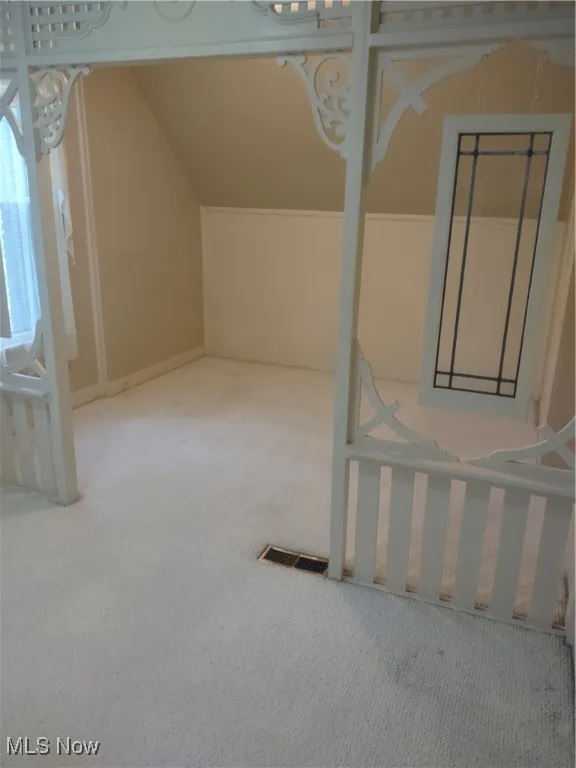 Bonus room with visible vents, vaulted ceiling, and carpet