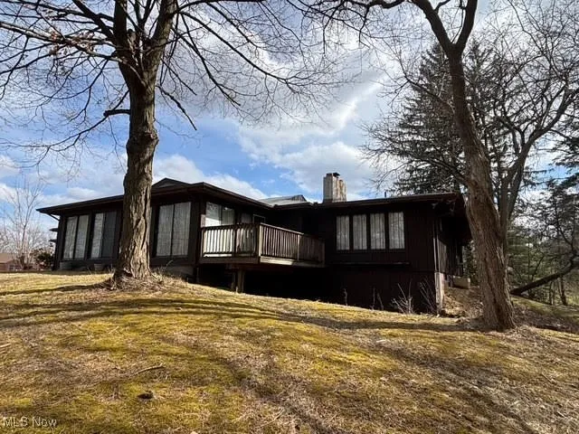 Rear view of property with a wooden deck and a chimney