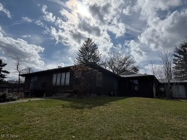 Rear view of house featuring a yard
