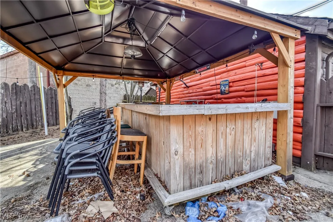 View of patio with fence, a gazebo, and outdoor dry bar