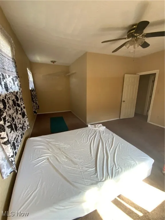 Carpeted bedroom with baseboards and ceiling fan