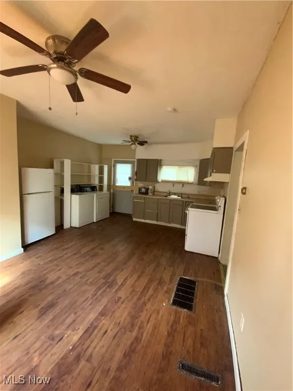 Kitchen featuring refrigerator, range, a sink, washer / clothes dryer, and visible vents