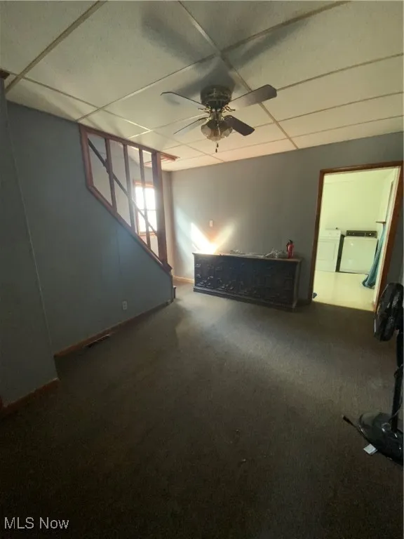 Spare room featuring independent washer and dryer, baseboards, a ceiling fan, carpet floors, and a paneled​​‌​​​​‌​​‌‌​‌‌​​​‌‌​‌​‌​‌​​​‌​​ ceiling