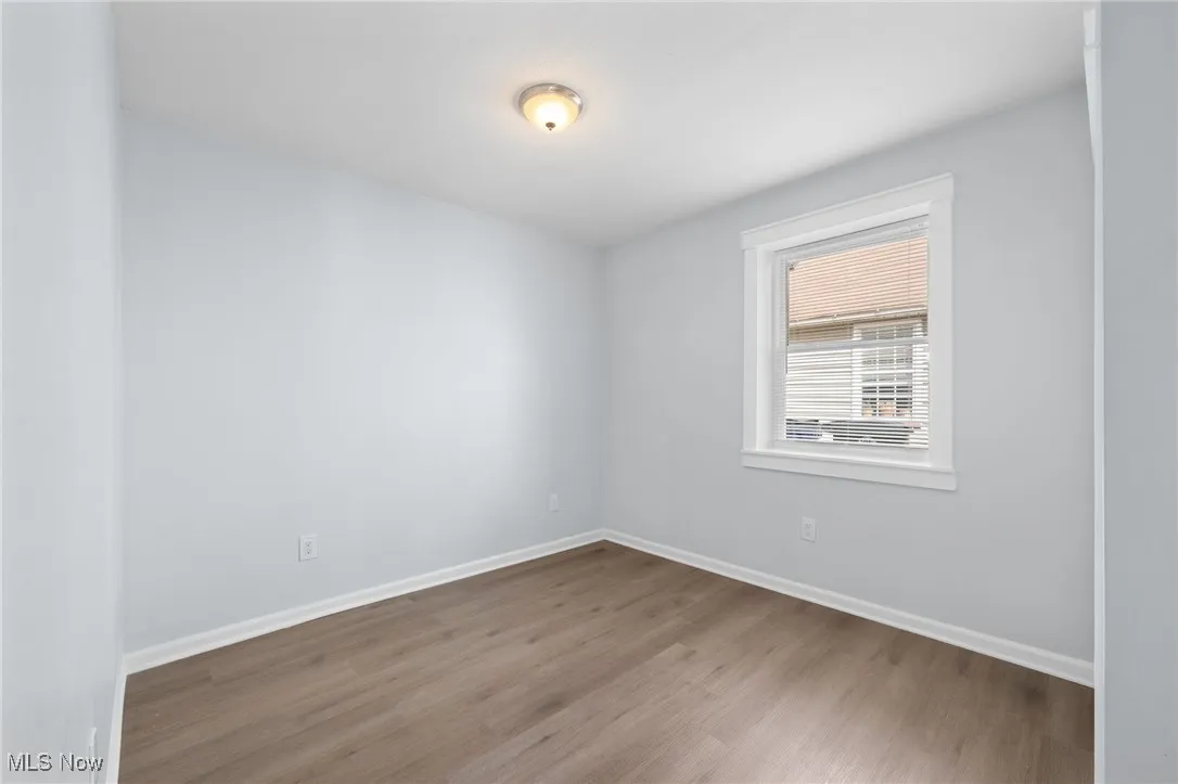 Bedroom with baseboards and wood style floors