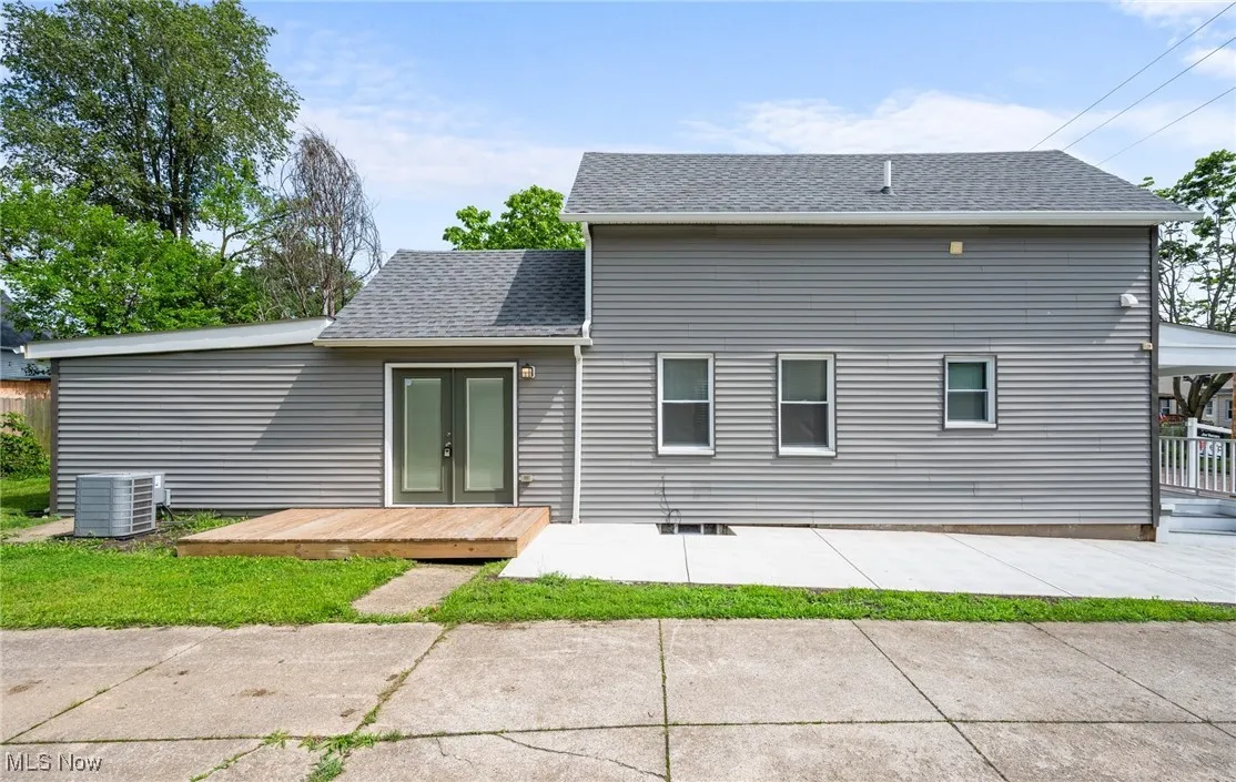 Side view of property featuring french doors, and a wooden deck