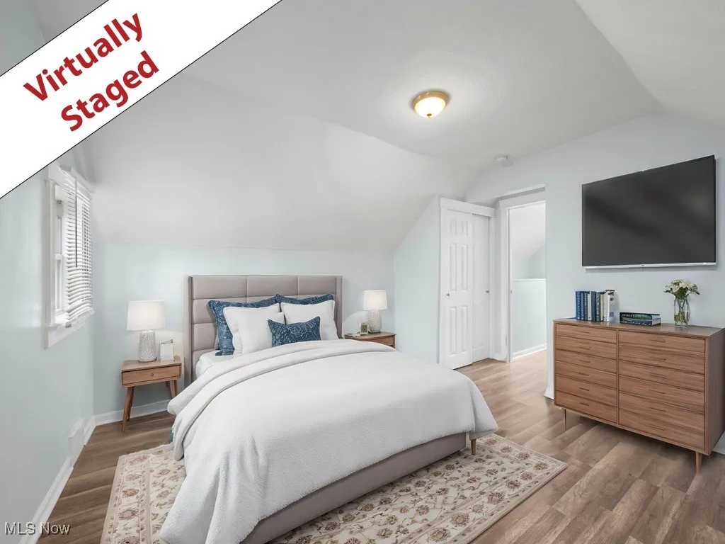 Bedroom featuring wood finished floors, baseboards, and lofted ceiling