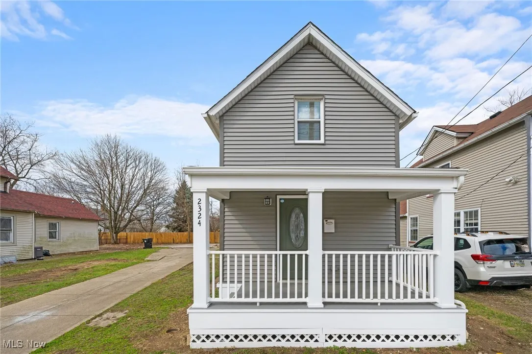 View of front of home featuring covered porch and fence