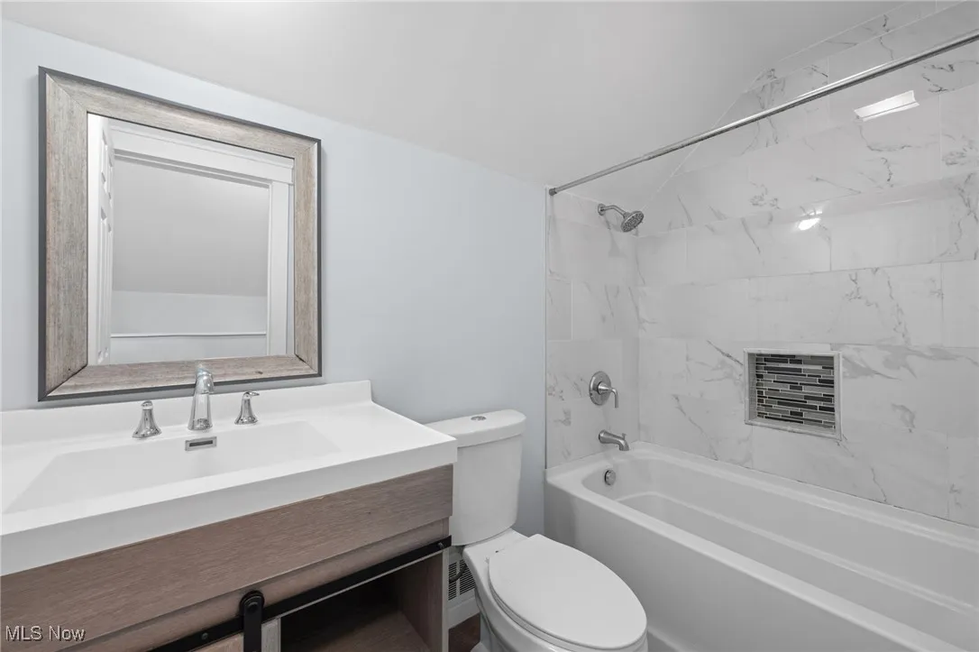 Full bath featuring toilet, vanity, and tub / shower combination