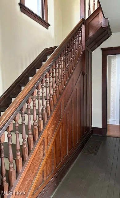 Stairway with baseboards and wood-type flooring