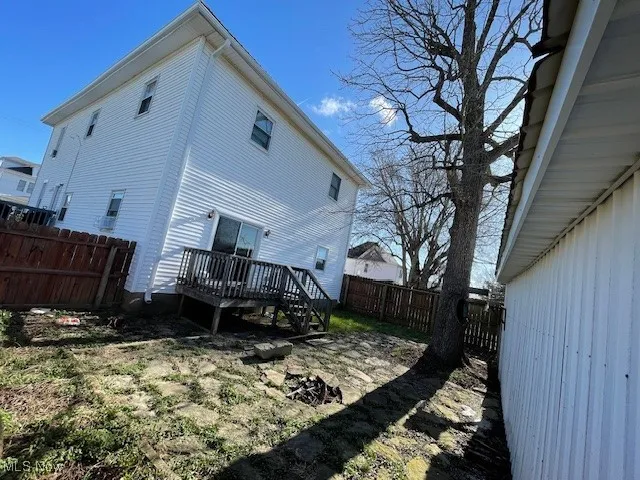 Rear view of house with a fenced backyard and a deck