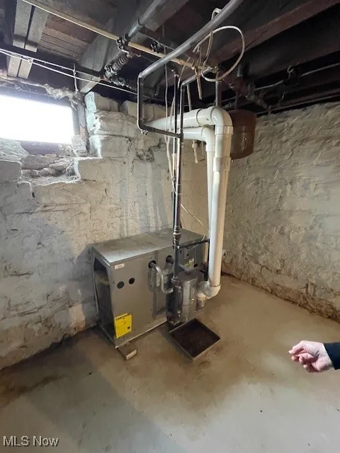 Unfinished basement featuring a heating unit