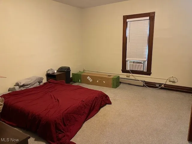 Bedroom with cooling unit and carpet flooring
