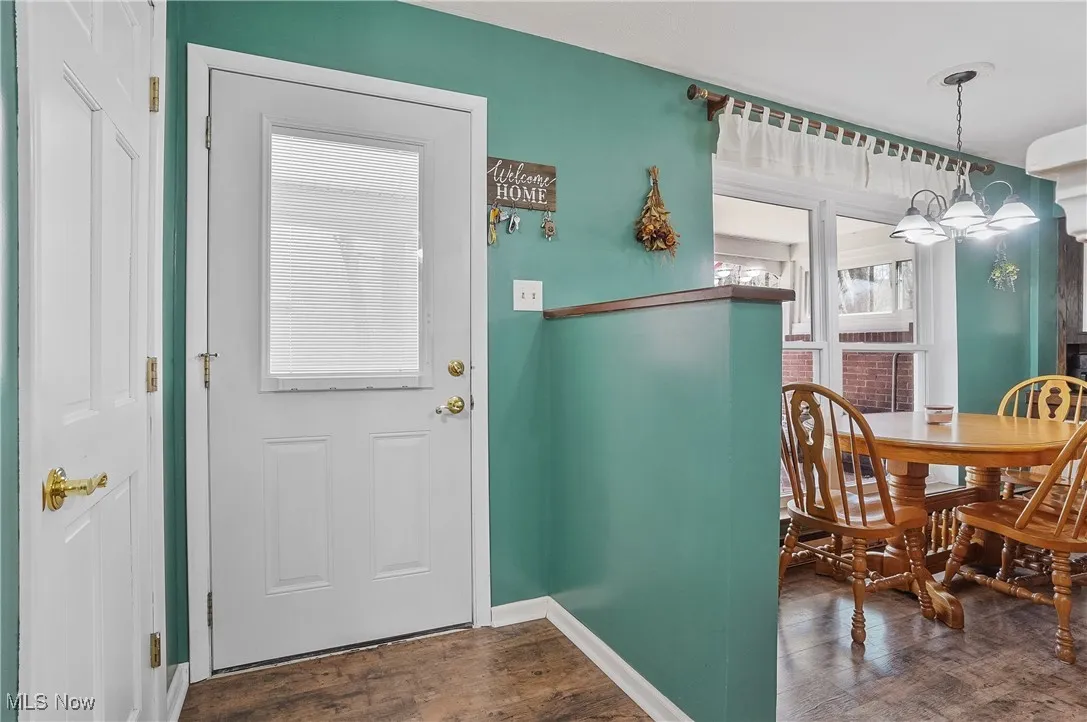 Entrance foyer with baseboards and wood finished floors