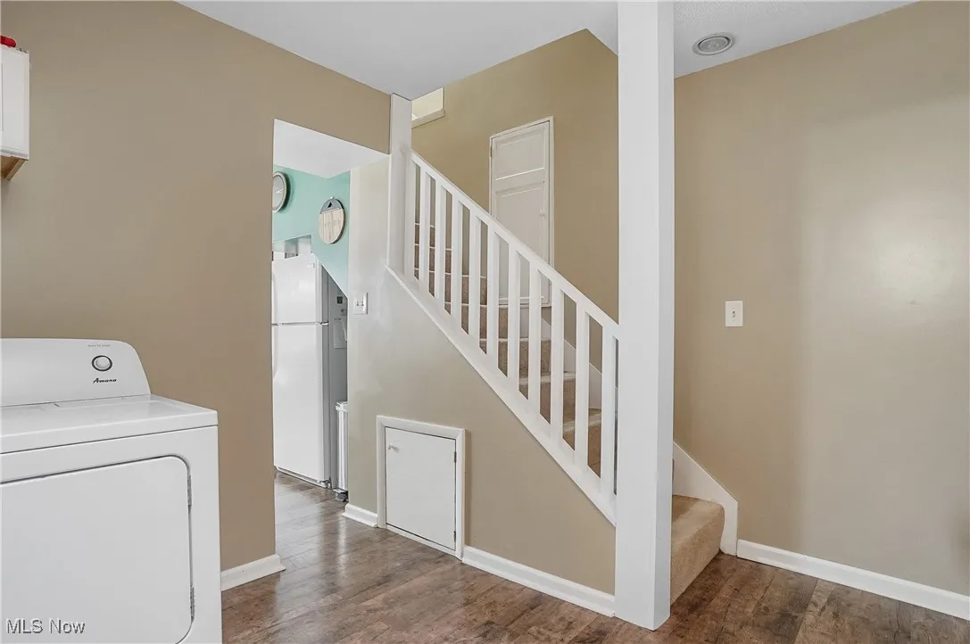 Laundry area with washer / clothes dryer, baseboards, laundry area, and wood finished floors