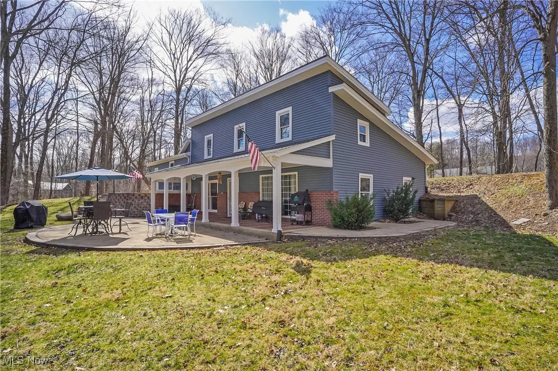 Back of property featuring a patio, brick siding, and a lawn