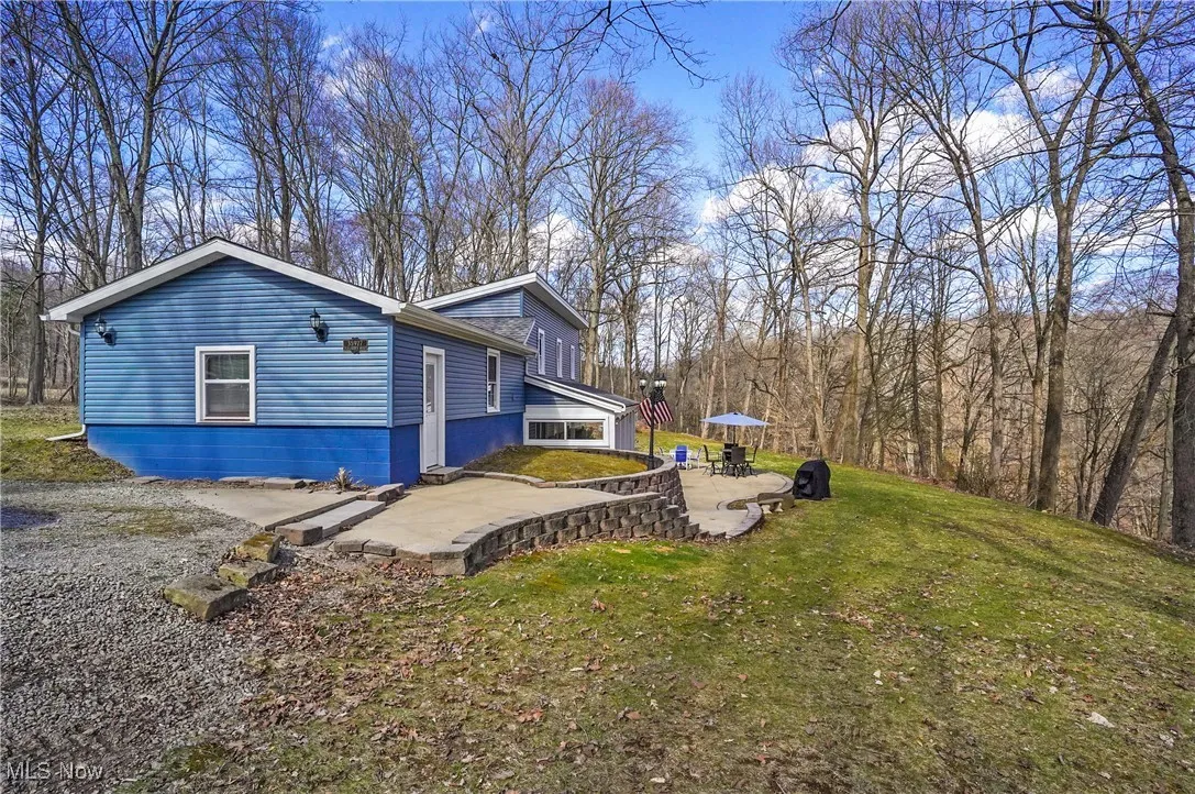 View of property exterior with a patio and a yard